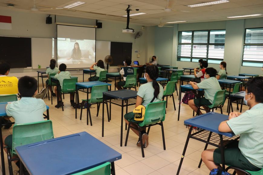 A classroom of primary school students watching a video