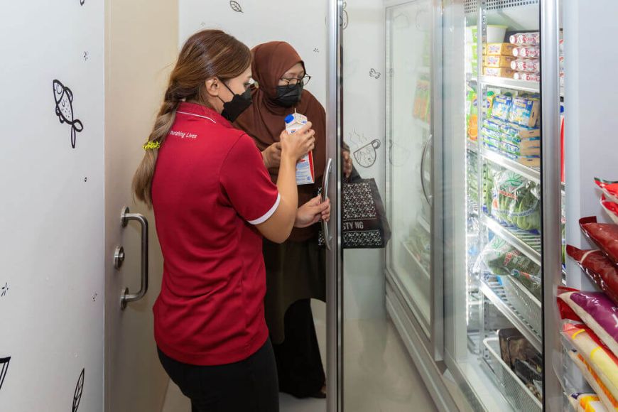 FFTH Staff helping beneficiary with shopping at the Community Shop @ Punggol